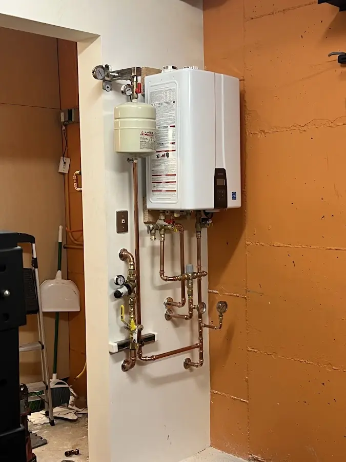 Plumbing technician inspecting water heater connections in Athens